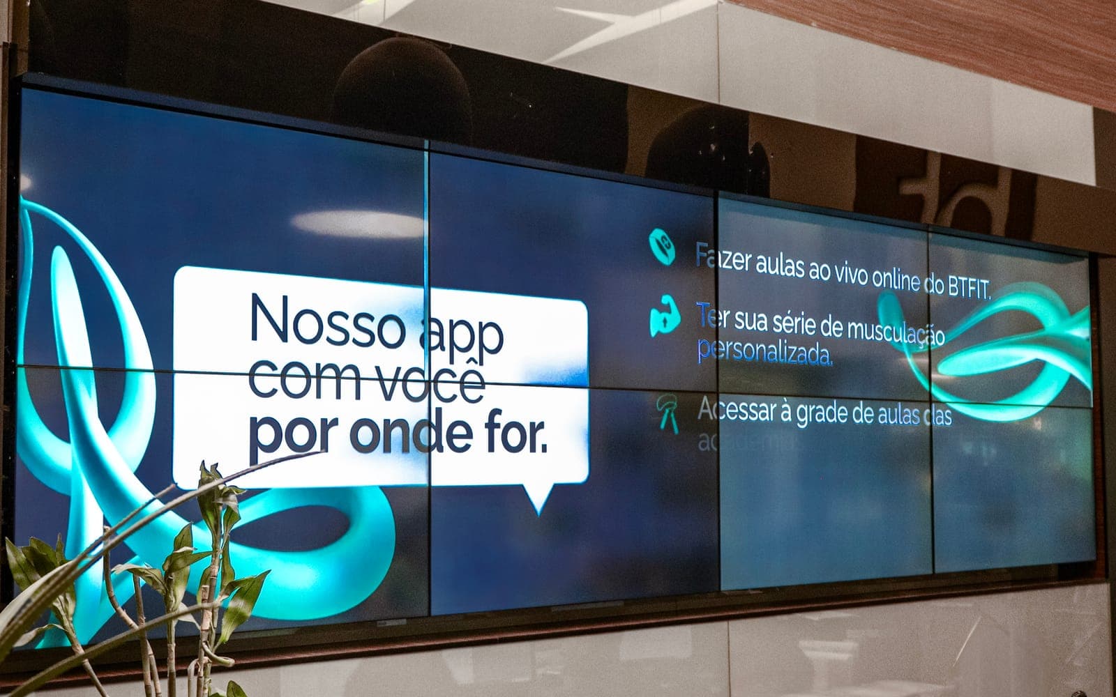 Painel de telas exibindo um comunicado com lista de avisos, em área de circulação