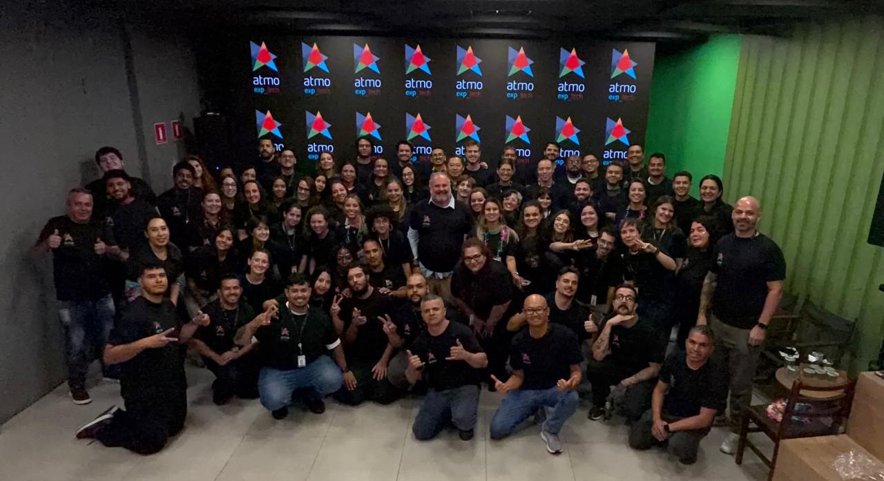 Equipe da Atmo reunida em frente ao palco de um evento